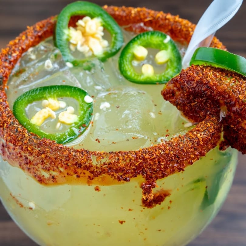 Spicy margarita with a chili-lime rim, jalapeño slices, and a chili-dusted lime wedge.