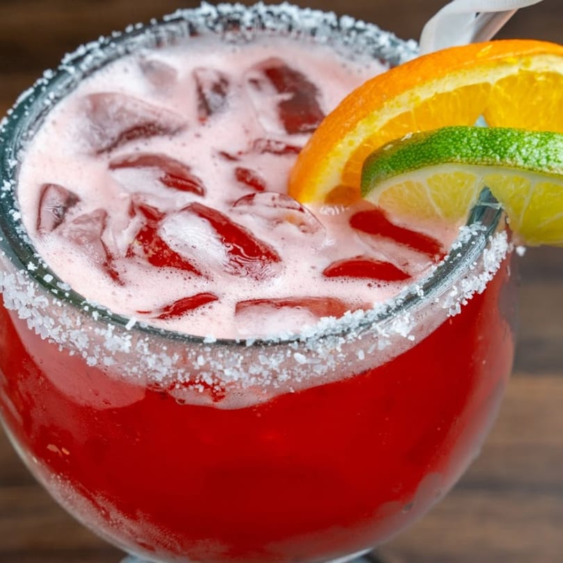 A vibrant red Habaneros Fresh Mexican Grill margarita with ice, salt rim, and citrus slices.