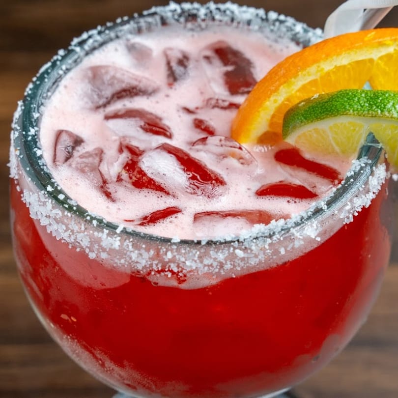 Close-up of a vibrant red margarita with ice, salt rim, and citrus garnishes from Habaneros Fresh Mexican Grill.